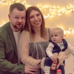 Rodzina z uśmiechniętym dzieckiem świętująca specjalną okazję.