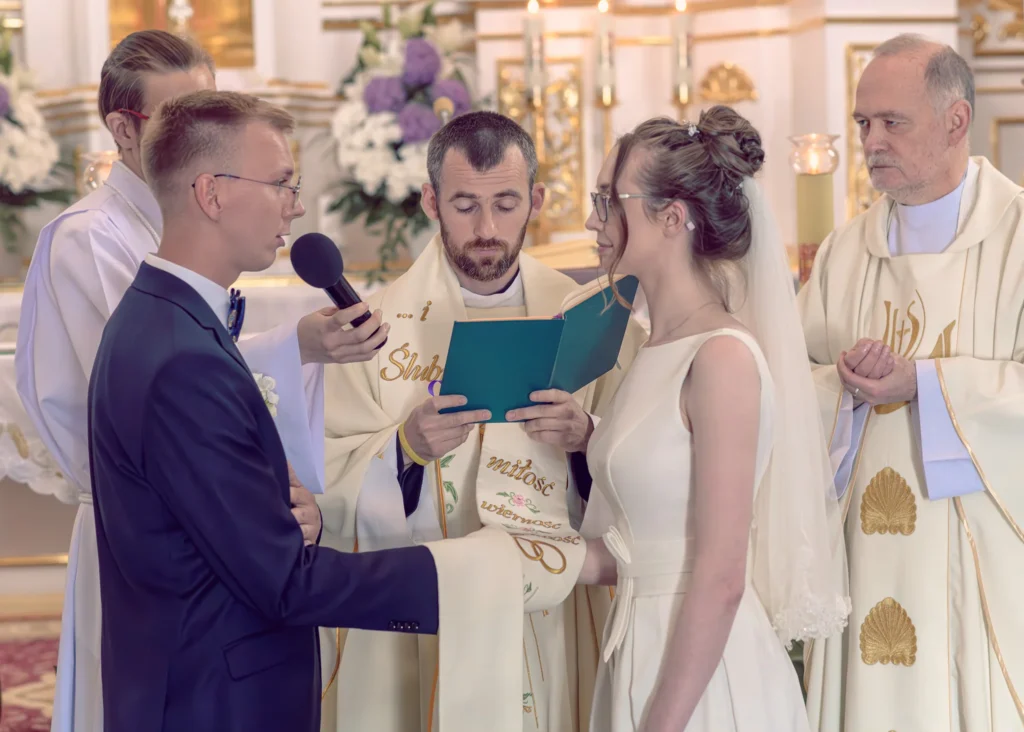 Para młoda składająca przysięgę małżeńską w kościele podczas ceremonii ślubnej.