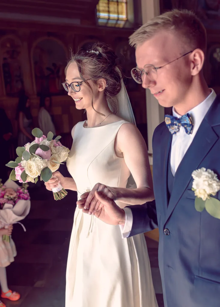 Szczęśliwi nowożeńcy wychodzący z kościoła po ceremonii ślubnej.