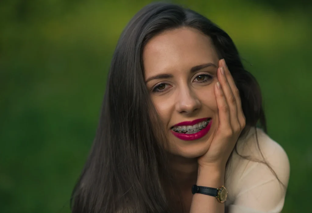 Uśmiechnięta kobieta z aparatem ortodontycznym w parku