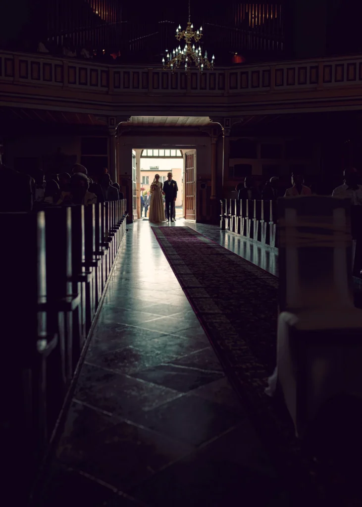 Para młoda wchodząca do kościoła, rozpoczynająca swoją uroczystość ślubną.